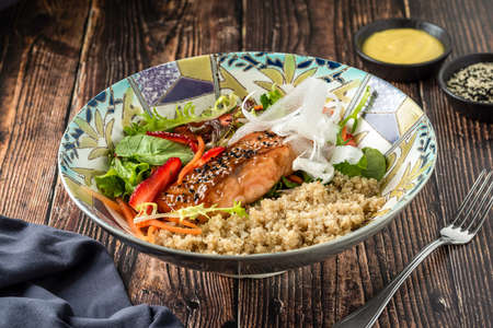 Grilled salmon with quinoa salad on brown bowl.の写真素材