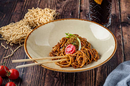 Tomato and pepper noodles on wooden table