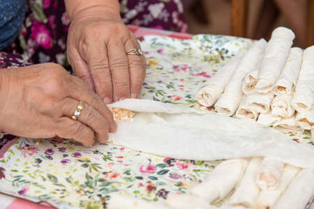 Housewife making putting cheese in yufka, make traditional Turkish smoking boregi (cigarette borek).