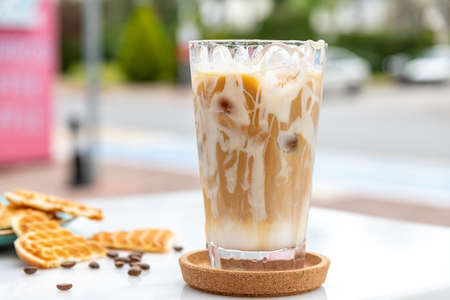 Iced caramel latte coffee in a tall glass with caramel syrupの写真素材