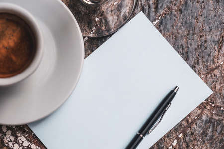 Top view of notebook, pencil and cup of coffee on stone table background.の写真素材