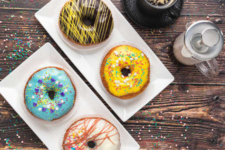 Delicious donuts decorated with different decorations on wooden tableの写真素材
