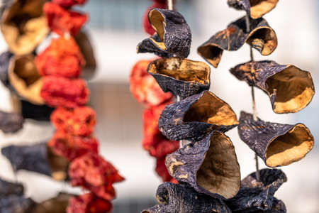 Dry eggplant and dry bell chili hanging in the market, local ingredient, closeup selective focus on blurred background.の写真素材