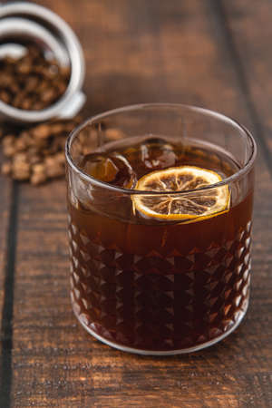 Refreshing iced coffee lemonade in crystal glass cup on wooden table