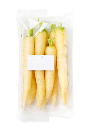 Packaged and labeled parsnip or yellow carrot on an isolated white backgroundの写真素材