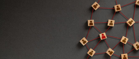 Organization structure, social network and teamwork concept on dark background. Business people icon on wooden cube blocks connecting network of connections.の写真素材