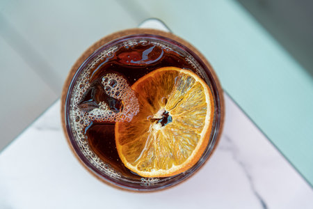 A cup of Iced Americano Coffee or Cold Brew coffee on a marble table in a coffee shop