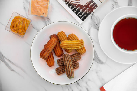 Churros with curry, olives and tomato paste on wooden table with Turkish teaの写真素材