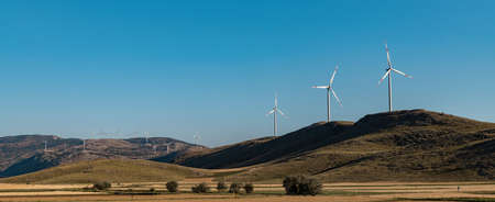 clean electricity producing wind turbine or windmill built on a windy mountain ridgeの写真素材