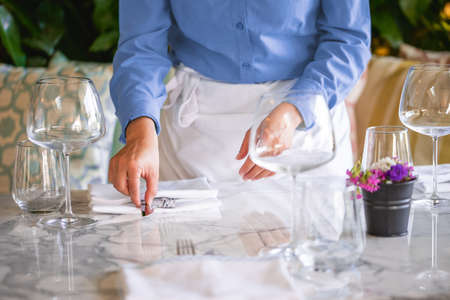 Waitress serving the empty table of the luxury restaurantの写真素材