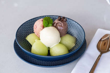 Fruit ice cream on melon balls on marble tableの写真素材