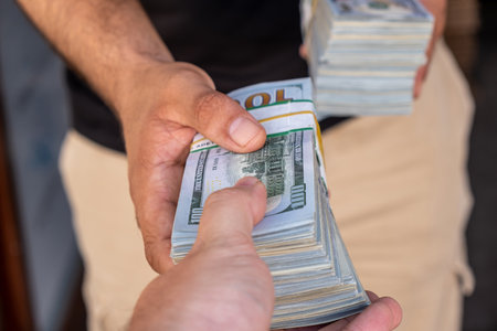 Bundles of US dollars in the hands of businessman. selective focus