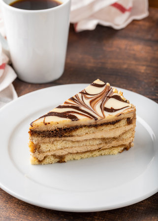 A slice of white chocolate and caramel cake on wooden tableの写真素材