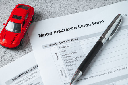 Motor or car insurance claim form with ballpoint pen and car model
