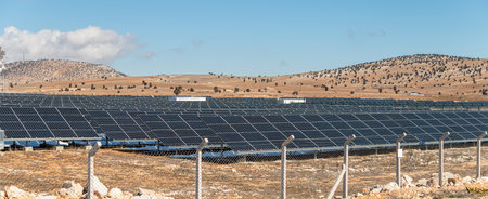 Solar field with fenced solar panels at sunset