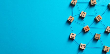 Organization structure, social network and teamwork concept on blue background. Business people icon on wooden cube blocks connecting network of connectionsの写真素材