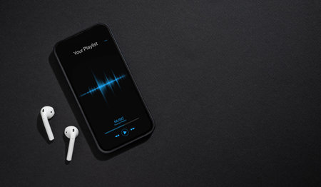 Smartphone with music player app open on screen on dark gray backgroundの写真素材