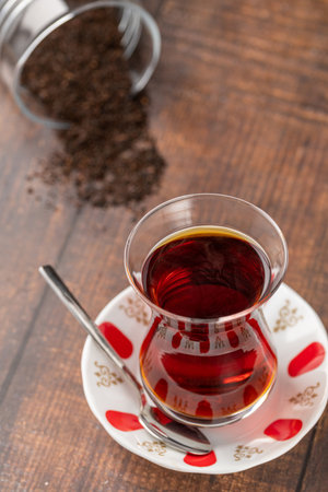 Freshly brewed turkish tea in thin-waisted glass cup on wooden tableの写真素材