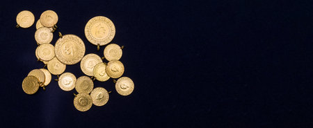The pile of full, half and quarter Turkish gold coins on a dark navy blue backgroundの写真素材
