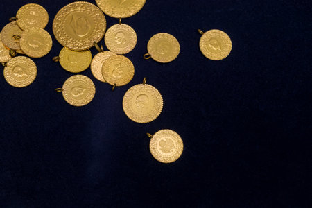 The pile of full, half and quarter Turkish gold coins on a dark navy blue backgroundの写真素材