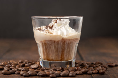 Hot espresso con panna in glass cup on wooden table