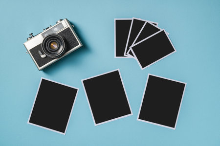 Vintage photo camera and empty photo frames on blue background. Travel moment conceptの写真素材