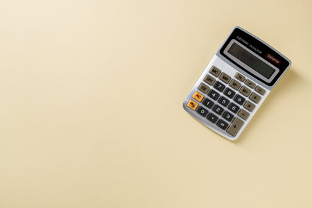 Top view of electronic calculator on yellow backgroundの写真素材
