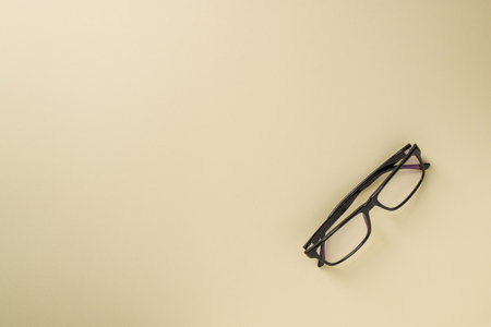 Prescription glasses with black frames on a yellow background