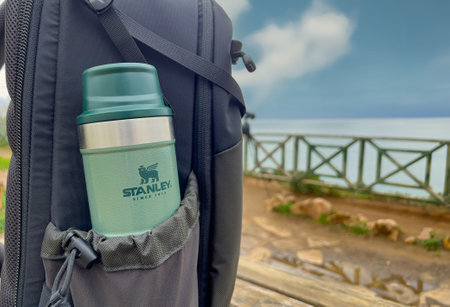 Antalya, Turkey - February 9, 2024: Stanley Action Trigger stands next to traveler's backpackのeditorial素材