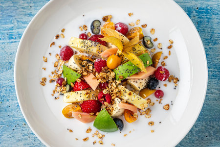Mixed fruit salad with fruits such as banana, strawberry and pineapple on a white porcelain plate