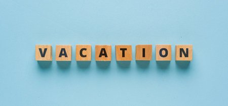 Vacation is written on wooden cubes on a blue background