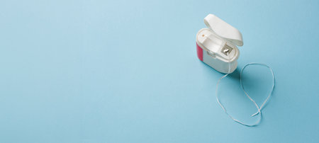 Top view of dental floss in white box on blue background