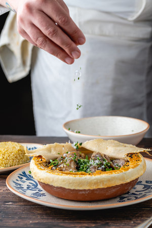 Lamb shank with bulgur pilaf and dough-covered top from traditional Turkish cuisine