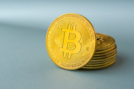 Close-up of a golden shiny Bitcoin BTC Cryptocurrency Coin on a blue backgroundの写真素材