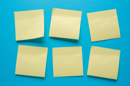 Blank post-it notes stuck in order on a blue background