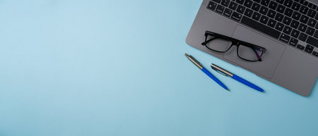 Top view of blue office desk with laptop and supplies. Flat lay business conceptの写真素材