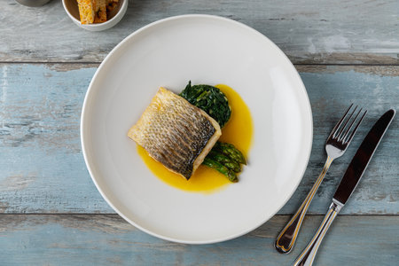 Grilled sea bass fillet served with garnishes in a fine dining restaurant