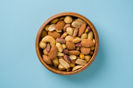Mixed nuts consisting of cashews, hazelnuts, almonds and pistachios in a wooden bowlの写真素材