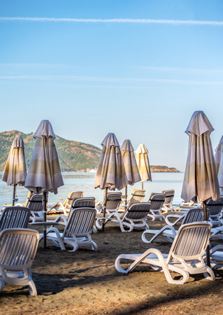 Rows of sunbeds and closed umbrellas on a sandy beachの写真素材