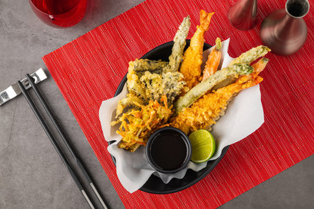 Tempura with vegetable tempura on a black ceramic plateの写真素材