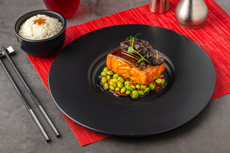 Grilled salmon fillet with edamame, elegantly served on a black plateの写真素材