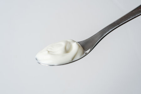 Spoonful of plain creamy yogurt on white background, minimal styleの写真素材