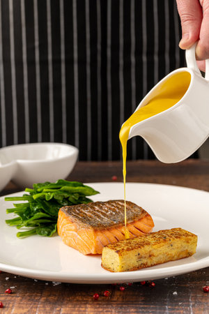 Seared salmon fillet served with wilted spinach and potato croquetteの写真素材