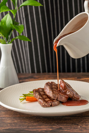 Juicy grilled filet medallions served with seasonal vegetables and sauceの写真素材