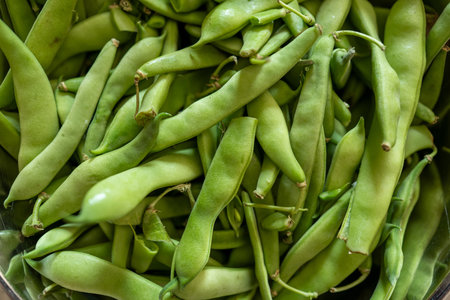 Close-up view of fresh green beans stacked in bulk