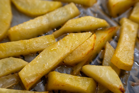 Homemade golden potato wedges baked in the oven, close-up