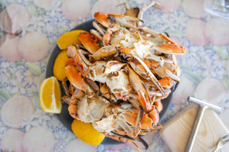 Freshly steamed blue crabs served with lemon wedges on a tableの写真素材