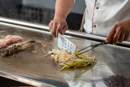 Chef cooking on a teppanyaki grill