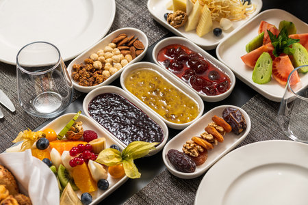 Assorted breakfast platter with jams, fruits, nuts, and cheeseの写真素材