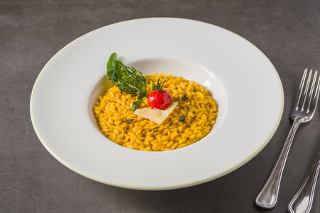 Porcini mushroom risotto on a white porcelain plate on a stone tableの写真素材
